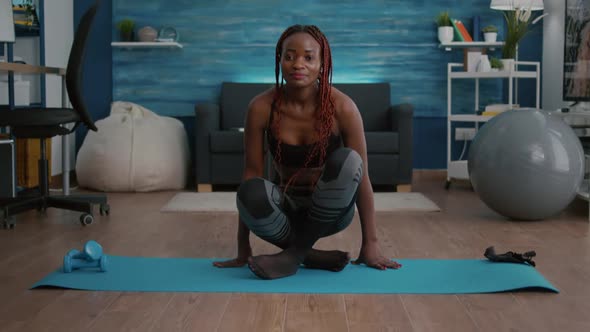 Athlete Slim Woman with Dark Skin Getting in Lotus Position on Yoga Map