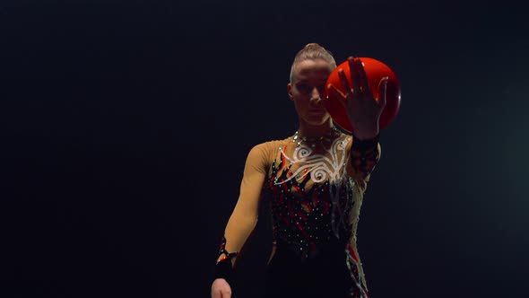 Graceful Girl Rolling Ball on Hands Indoors