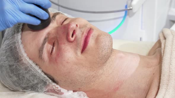 Man Receiving Facial Ultrasound Cavitation Treatment By Cosmetologist