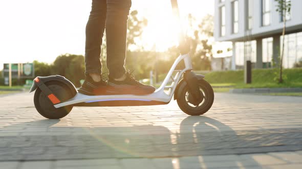 Attractive Man Stands Scoots and Rides on the Electric Kick Scooter