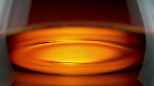 Super Slow Motion Detail Shot of Swirling Whiskey in Glass at 1000Fps.