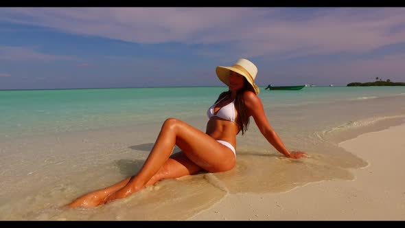 Female model tanning on paradise sea view beach adventure by blue green lagoon and white sandy backg
