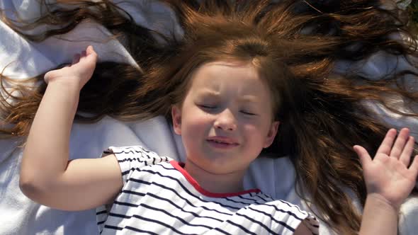 Child Lying on Blanket Having Picnic in Summer Park