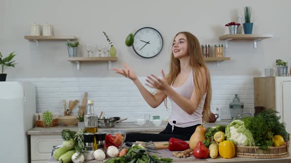 Girl Recommending Eating Raw Vegetable Food. Showing Avocado in Hands. Weight Loss and Diet Concept