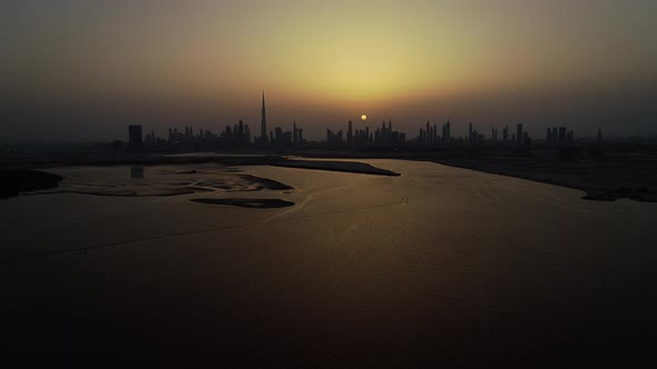 Aerial view of Dubai skyscrapers and bay at sunset, UAE.