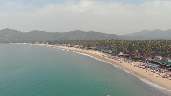 Long sand stretch of Palolem beach. Tranquil turquoise sea waters. Goa, India.