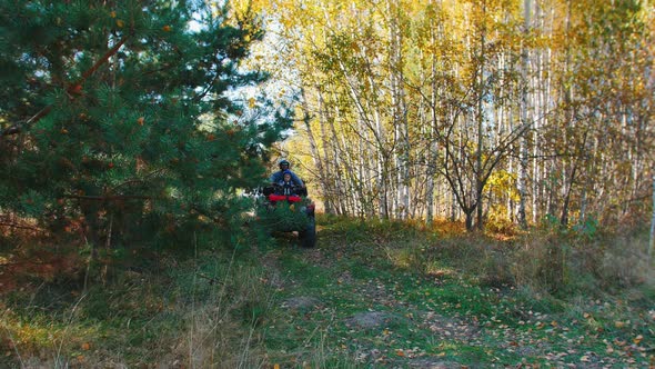 Family with Little Kid Rides Atv in the Autumn Forest