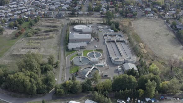 Aerial backward movement shot of waste water treatment plant for filtration of dirty or sewage water