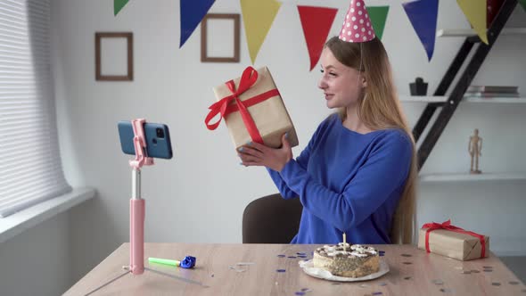 at Home a Blonde Woman is Sitting at the Table