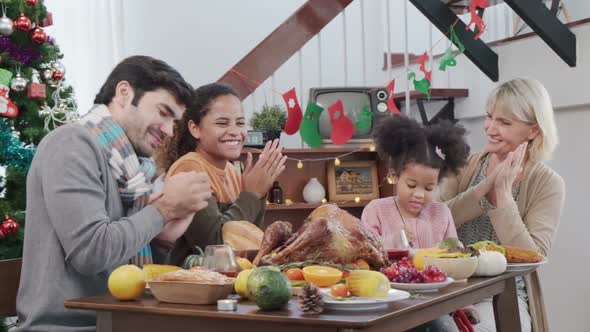 family having holiday dinner and cutting turkey Thanksgiving Celebration