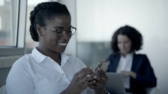 Smiling African American Woman Using Smartphone