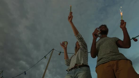 Low angle view of couple dancing with firework candles