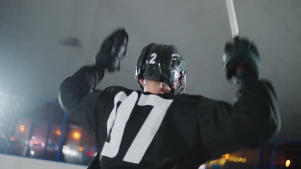 Back View Hockey Player Rejoices at the Victory in the Match Man in a Black Uniform Waving His Arms