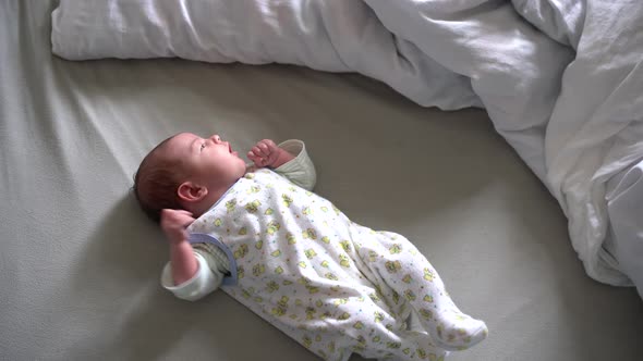 Newborn Baby Lies on the Bed and Shudders