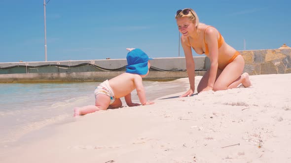 For the First Time, a Child Near the Ocean with His Mother Touches Salt Water 