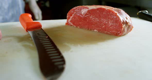 Butcher chopping meat in shop