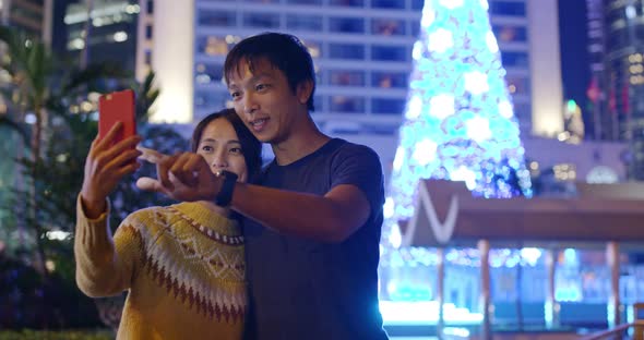 Couple take selfie in the city at night