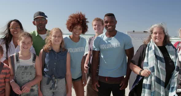 Volunteers standing together on beach in the sunshine 4k