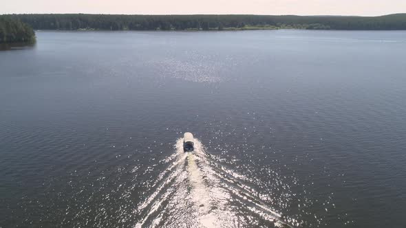 Aerial view of pleasure boat with people floats on the pond with forest 08