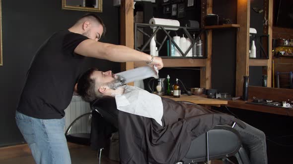 Barber Covering Face of Client with Towel