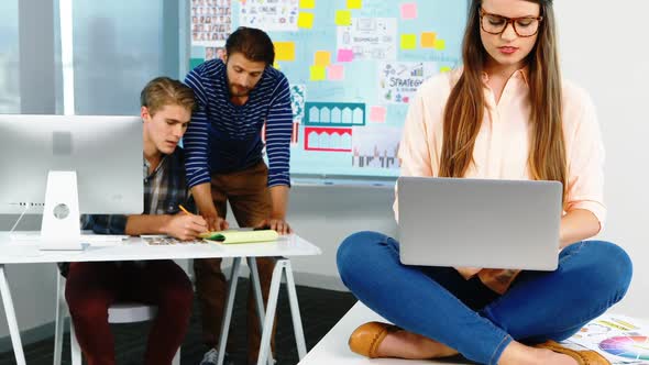 Female graphic designer using laptop in office