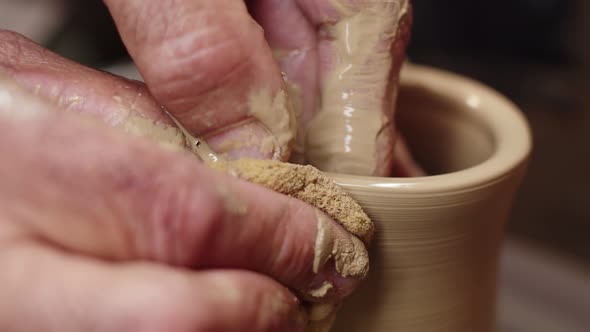 Artisans Hands Give the Spinning Clay on the Potters Wheel Shape By Sliding His Fingers Over It