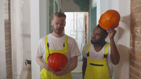 Two Diverse Renovation Workers Chatting and Relaxing During Break at Work