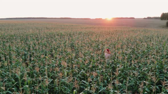 A Young Girl Happily Walking in Slow Motion Through a Corn Field