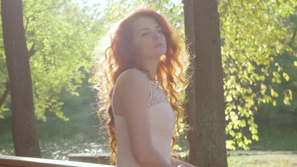 Pretty Redhead Thoughtful Woman Turning Around and Looking Away. Young Caucasian Girl Basking in the