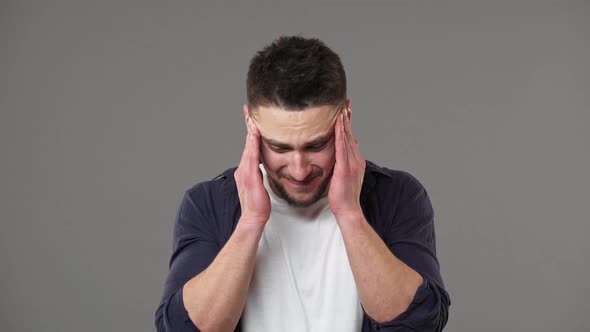 Portrait of Stressed Unhealthy Man 30s Rubbing Temples Because of Headache and Suffering From