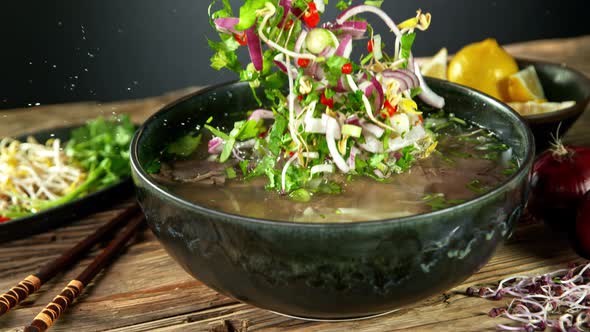 Super Slow Motion Shot of Ingredients Falling Into Beef Pho Soup at 1000 Fps.