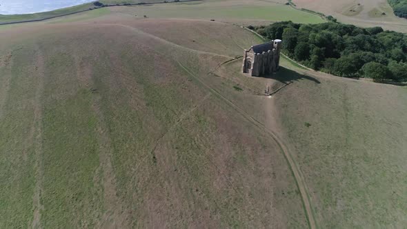 Forward tracking aerial over St Catherine's Chapel near Abbotsbury, Dorset. An almost top down angle