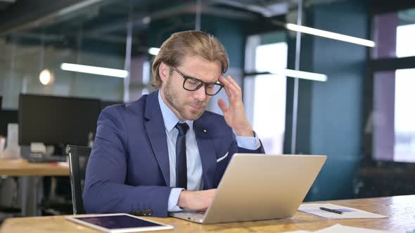 Tired Businessman Having Headache in Office