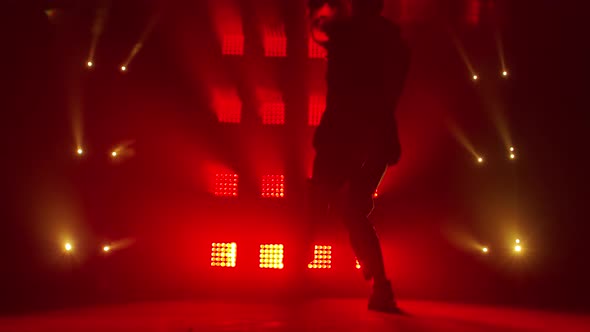 Silhouette of a Talented Young Hip Hop Dancer. Hip Hop Street Dance on a Stage in Dark Studio with