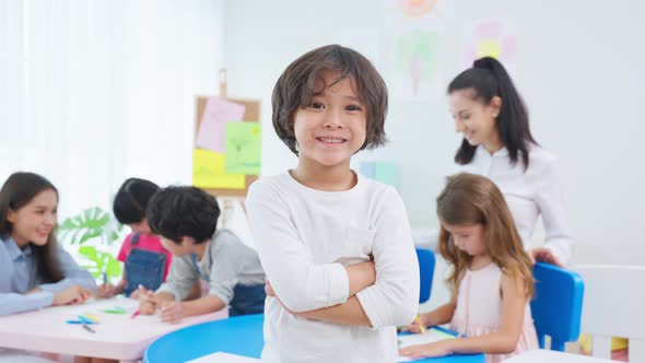 Portrait of Asian kid boy student stand with happiness in class room. alt