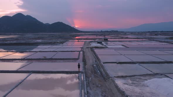 Rising aerial view of tourists exploring vast endless salt fields during golden hour in Phan Rang, V