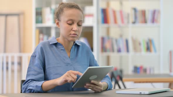 African Woman Reacting To Failure on Tablet in Library