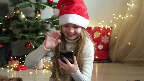 Little Cute Girl at Home During Christmas Eve Day Enjoy a Video Phone Call with Parents or Friends