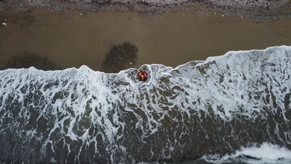 Aerial View From Above on Old Rusty Floating Marine Mine on the Beach and Volcanic Rocky Shores