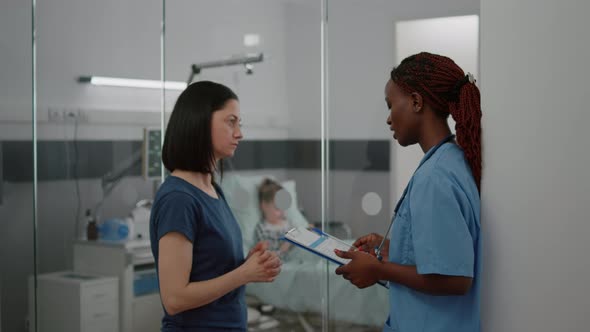 African American Practitioner Nurse Monitoring Sickness Symptom Explaining Medical Treatment