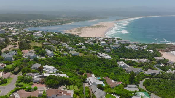 Aerial View of Luxury Houses on Slope with Green Vegetation Descending to Sea Coast