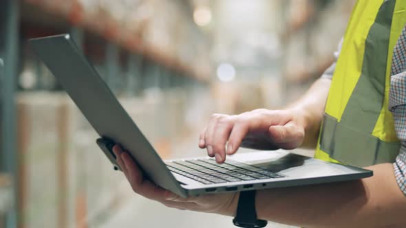 Close Up of a Laptop with a Male Specialist Typing on It