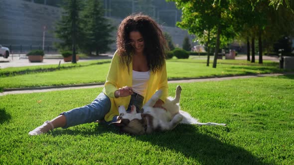 Happy Girl with Playful Husky Dog Outdoors