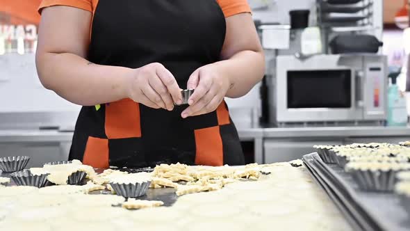 Pastry Chef Making Tartlets, Putting The Dough In Baking Dishes, At Kitchen Of Pastry Shop