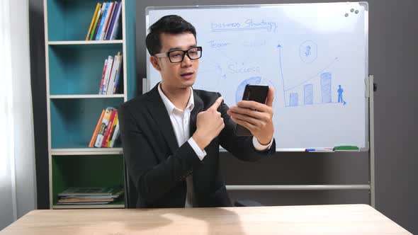 Asian Business Man Making Face time Video Calling With Smartphone At Home