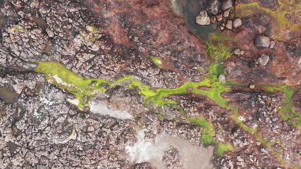 Aerial Top View of Rocky Beach in Faroe Islands Multicolored Rocks and Green Meadowocean Water on