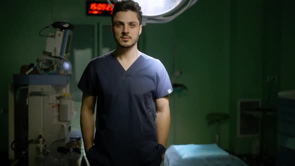 Medium Shot Portrait of Confident Middle Eastern Young Male Surgeon Standing in Operating Room