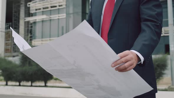 Engineer Helmet Checks a Construction Plan in New Microdistrict of the City