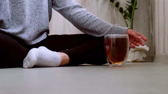 Young Millennial Blonde Woman Drinking Tea and Doing Yoga Exercise Stretching Fitness at Balcony