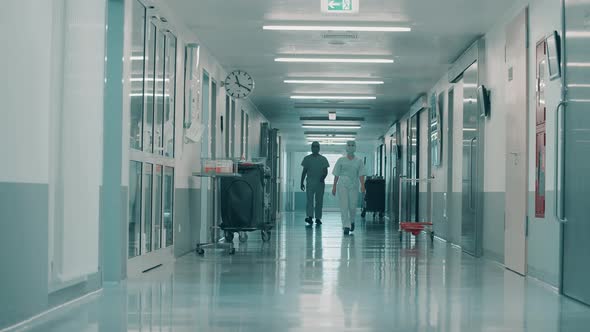 Hallway with Surgeons in Medical Uniform Walking Along It